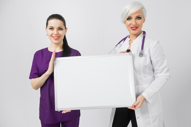 Doctor and nurse holding an empty magnetic Board isolated