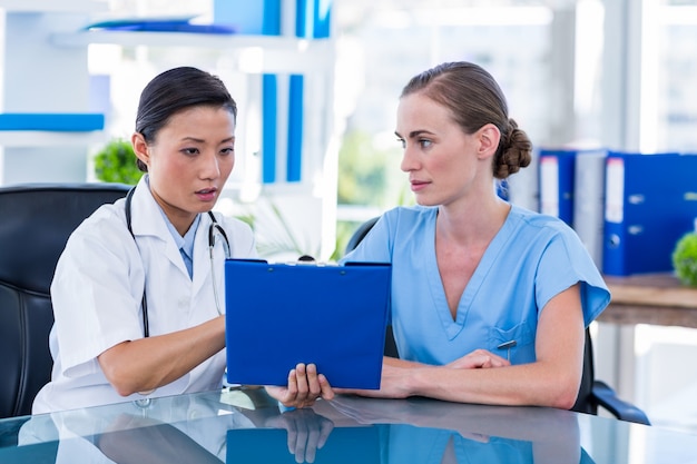 Doctor and nurse looking at clipboard