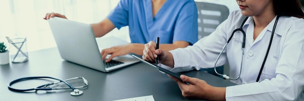 Foto dottore e infermiera in una riunione medica che discutono il piano di trattamento medico strategico insieme a un rapporto e un portatile concetto di formazione del laboratorio della scuola di medicina in banner panoramico neoterico