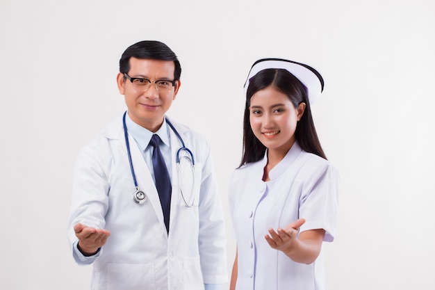 Doctor and nurse medical team pointing inviting hand at you