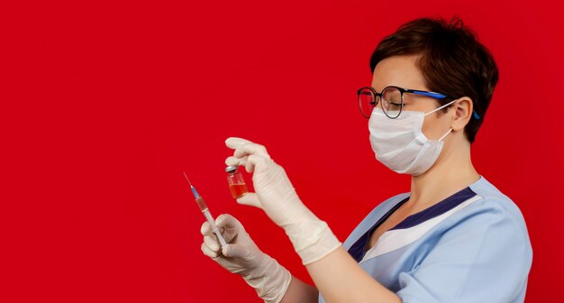 Врач или медсестра в нитриловых перчатках держит в руке вакцину