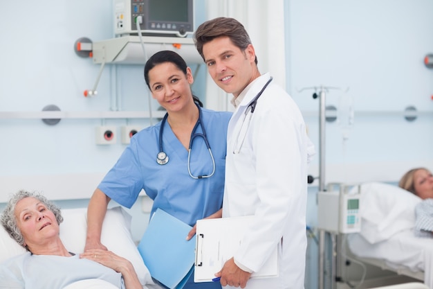 Doctor and nurse next to a patient