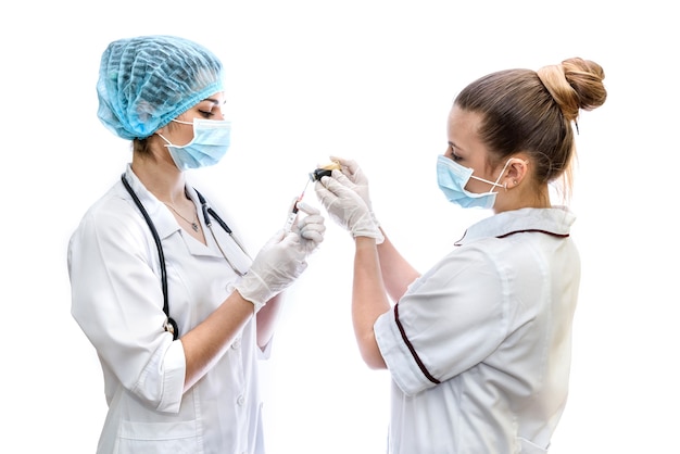 Doctor and nurse preparing injection isolated on white wall