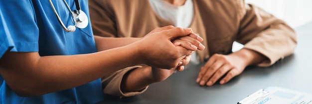 Foto dottore o infermiere che fornisce consulenza sanitaria compassionevole tenendo la mano di un giovane paziente per essere di supporto e professionale come personale medico in una clinica medica o in un ufficio ospedaliero neoterico