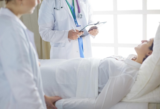 Doctor or nurse talking to patient in hospital