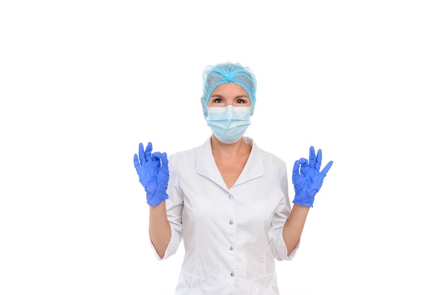 Doctor or nurse  wearing mask and medical gloves and shows ok gesture with two hands