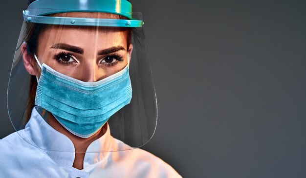 doctor nurse wearing protective gear of surgical mask and face shield protection against contagious