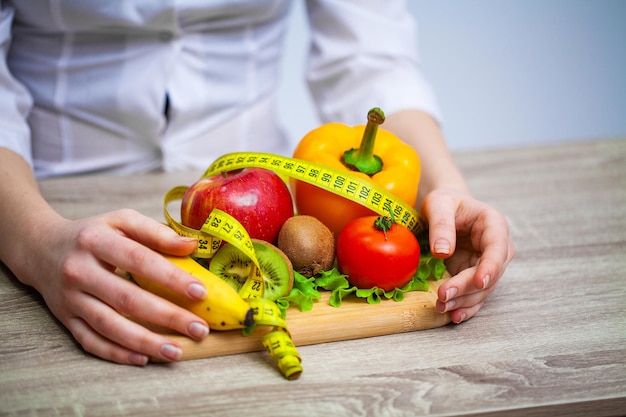 Foto medico nutrizionista che tiene frutta e verdura fresca per una dieta sana.