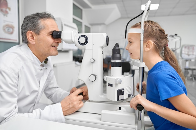 Photo doctor ophthalmologist examining eyes with test machine.