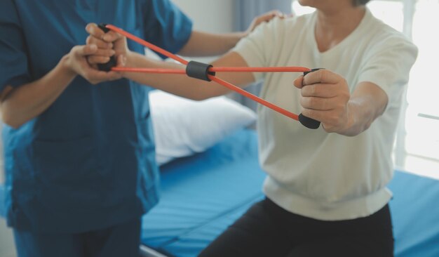 사진 병원이나 요양원에서 노인 여성과 의사 또는 간호사 또는 물리 치료사 간병인 운동