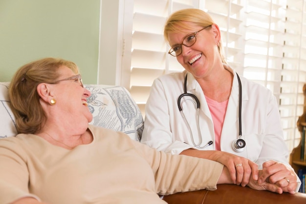 Фото Врач или медсестра разговаривают с сидящей пожилой женщиной