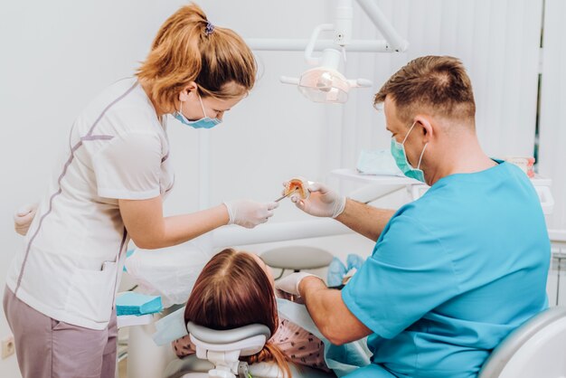 Doctor orthodontist explains to the patient how he will treat her