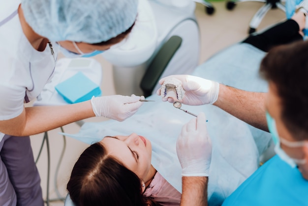 Doctor orthodontist explains to the patient how he will treat her