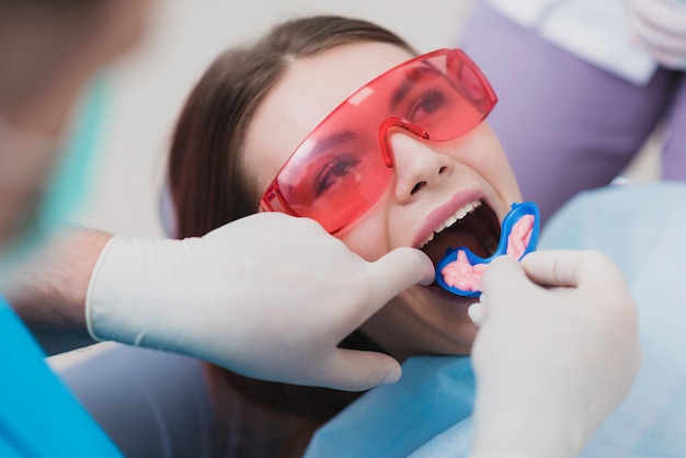 Doctor orthodontist performs a procedure for cleaning teeth