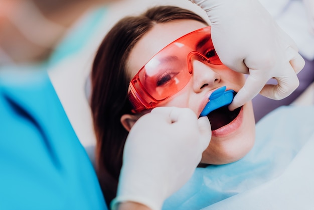 Doctor orthodontist performs a procedure for cleaning teeth