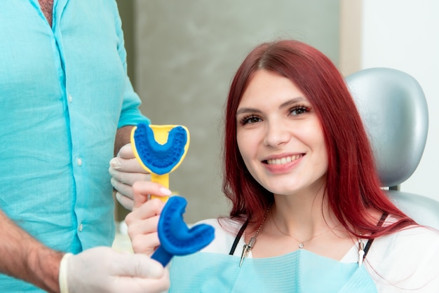 Doctor orthodontist shows the patient the result of the casts of her teeth