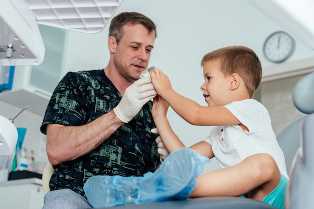 Doctor orthodontist tells the child how to care for teeth and maintain hygiene