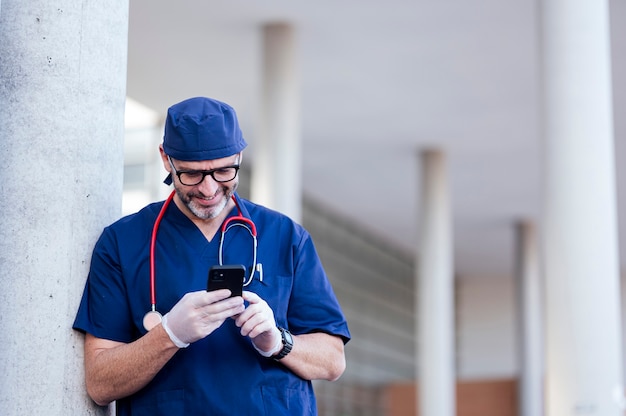 Medico fuori dall'ospedale utilizzando smart phone