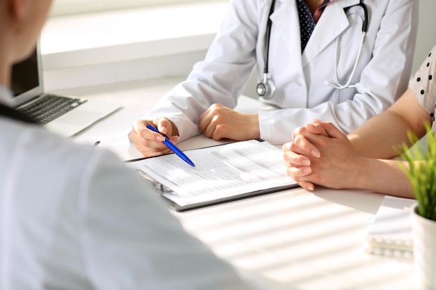 Doctor and patient are discussing something just hands at the table