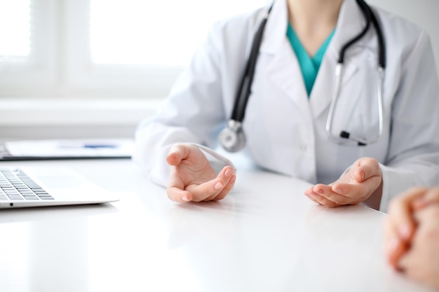 Doctor and patient are discussing something just hands at the table