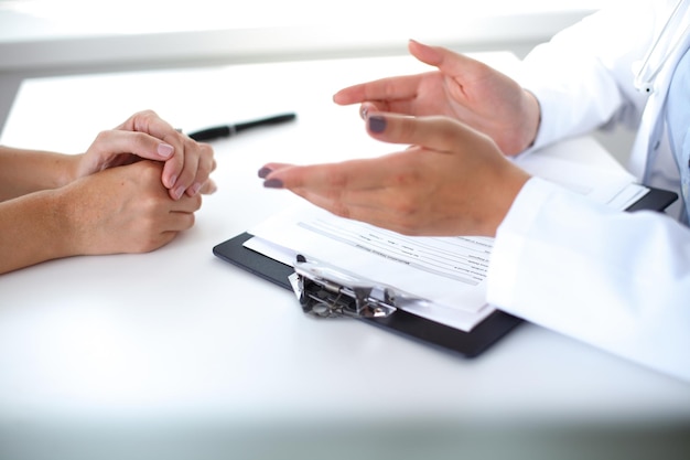 Doctor and patient are discussing something, just hands at the table.