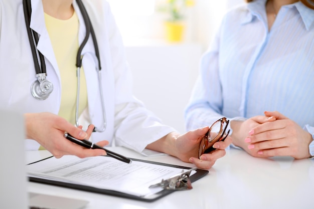 Doctor and patient are discussing something, just hands at the table.