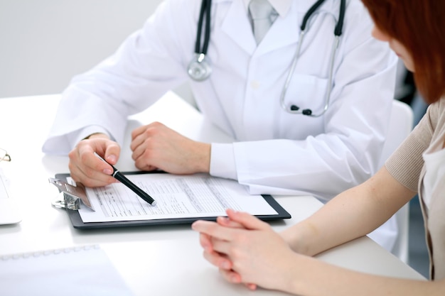 Doctor and patient are discussing something, just hands at the table.