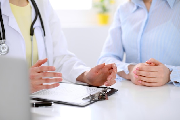 Doctor and patient are discussing something, just hands at the table.