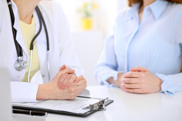 Doctor and patient are discussing something, just hands at the table.