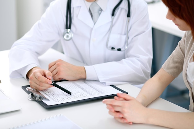 Doctor and patient are discussing something, just hands at the table.