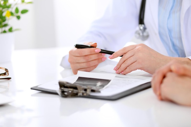 Doctor and patient are discussing something, just hands at the table.