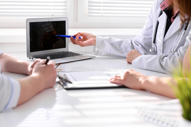 Doctor and patient are discussing something, just hands at the table.