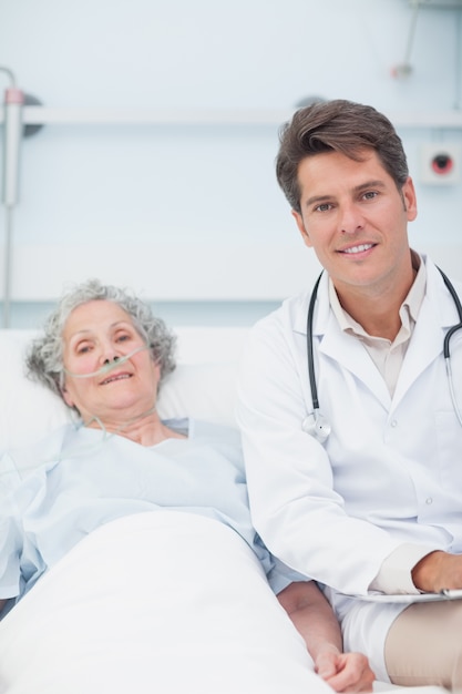 Doctor and patient on the bed looking at camera