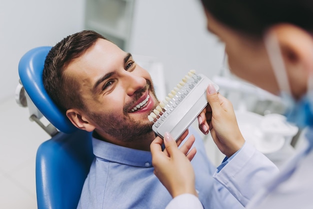 Medico e paziente che scelgono gli impianti dentali nella moderna clinica odontoiatrica