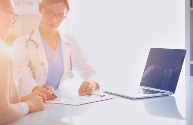 Doctor and patient couple are discussing somethingsitting on the desk