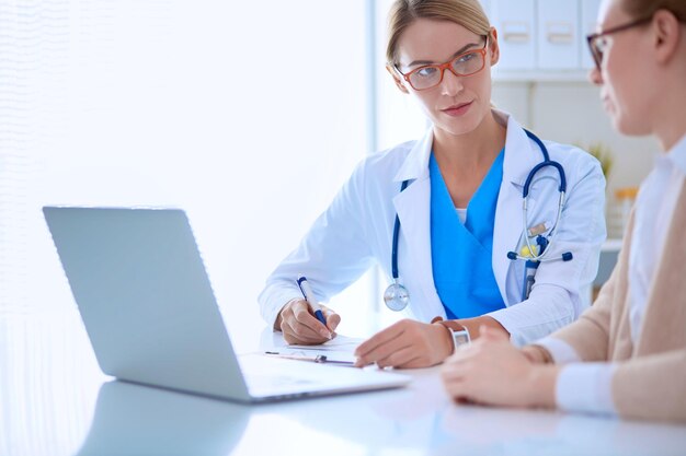 Doctor and patient couple are discussing somethingsitting on the desk