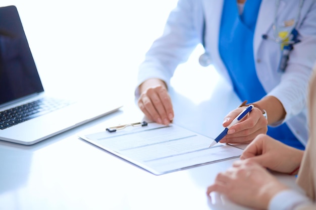 Doctor and patient couple are discussing somethingsitting on the desk