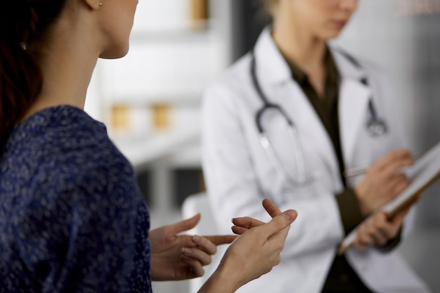 Doctor and patient discussing current health examination while sitting in clinic. Perfect medical service in hospital. Medicine concept.