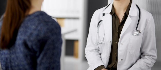 Doctor and patient discussing current health examination while sitting in clinic. Perfect medical service in hospital. Medicine concept.