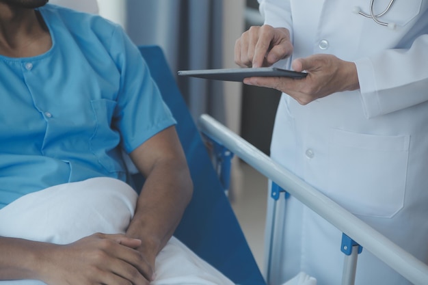 Doctor and patient discussing current health examination while sitting at the desk in clinic office closeup Medicine concept