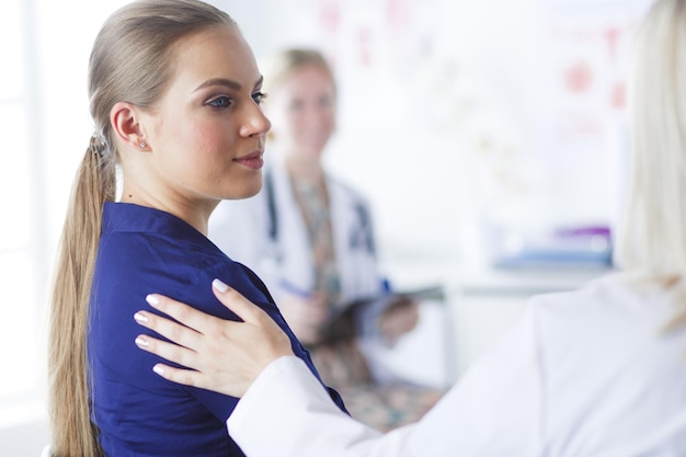 Photo doctor and patient discussing something while sitting at the table medicine and health care concept