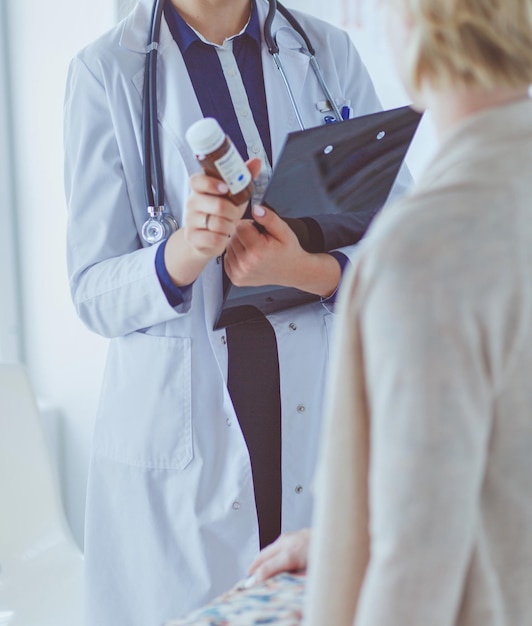 Doctor and patient discussing something while sitting at the table . Medicine and health care concept