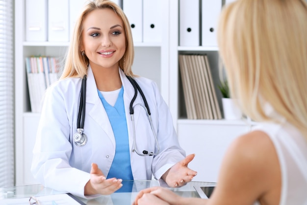 Doctor and  patient  discussing something while sitting at the table . Medicine and health care concept