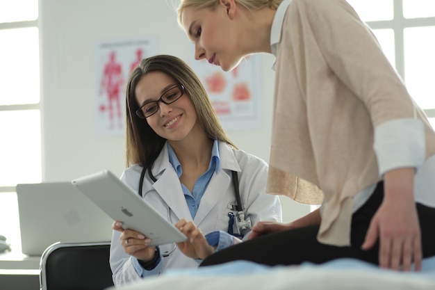 Doctor and patient discussing something while sitting at the\
table medicine and health care concept