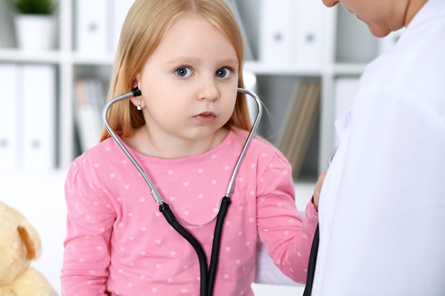Врач и пациент в больнице Ребенок осматривается врачом со стетоскопом