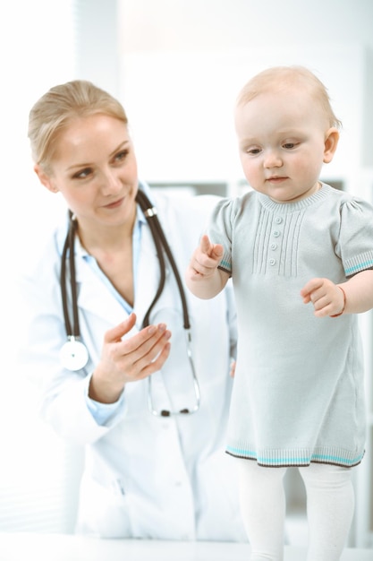 Врач и пациент в больнице. Маленькую девочку осматривает врач со стетоскопом. Концепция медицины.