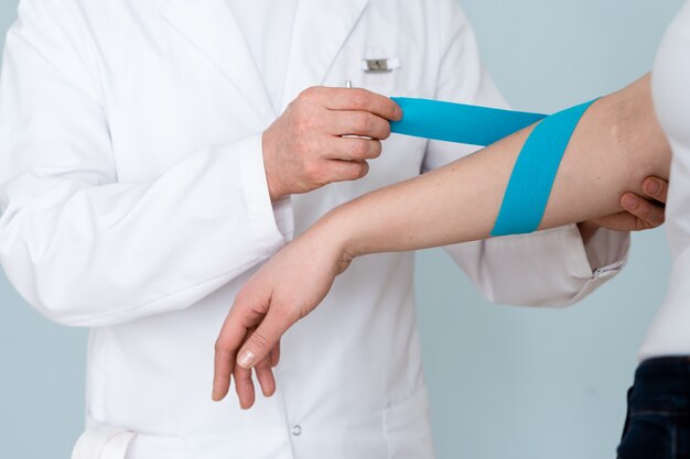 doctor and patient kinesio tape application on hand