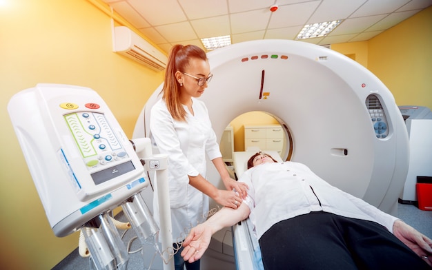 Doctor and patient in the room of computed tomography at hospital.