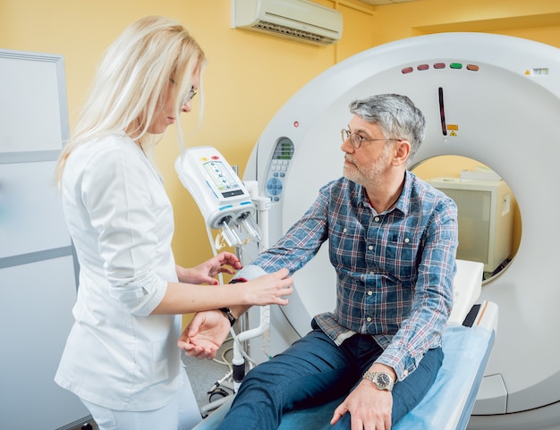 Doctor and patient in the room of computed tomography at hospital.