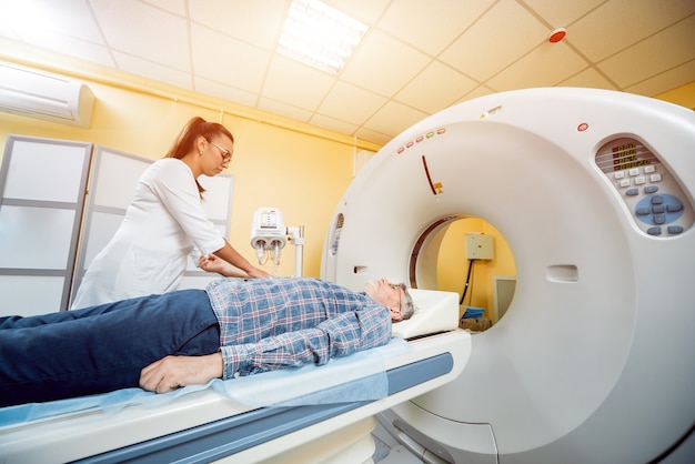 Doctor and patient in the room of computed tomography at hospital.